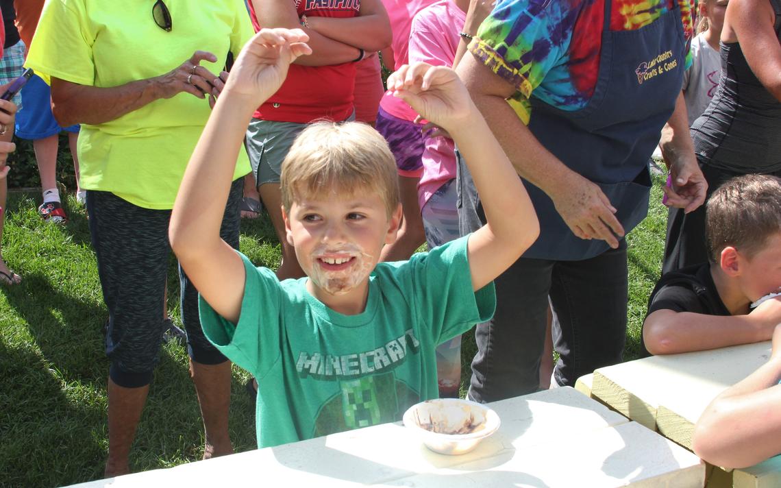 Sam Parsons, of Isanti, celebrates his first place victory in the 6-8 age group at Lake Country Crafts and Cones' ice cream eating contest Thursday, Aug. 11
