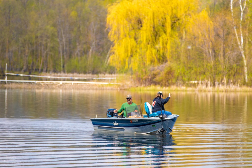 Two people fish on a speedboat