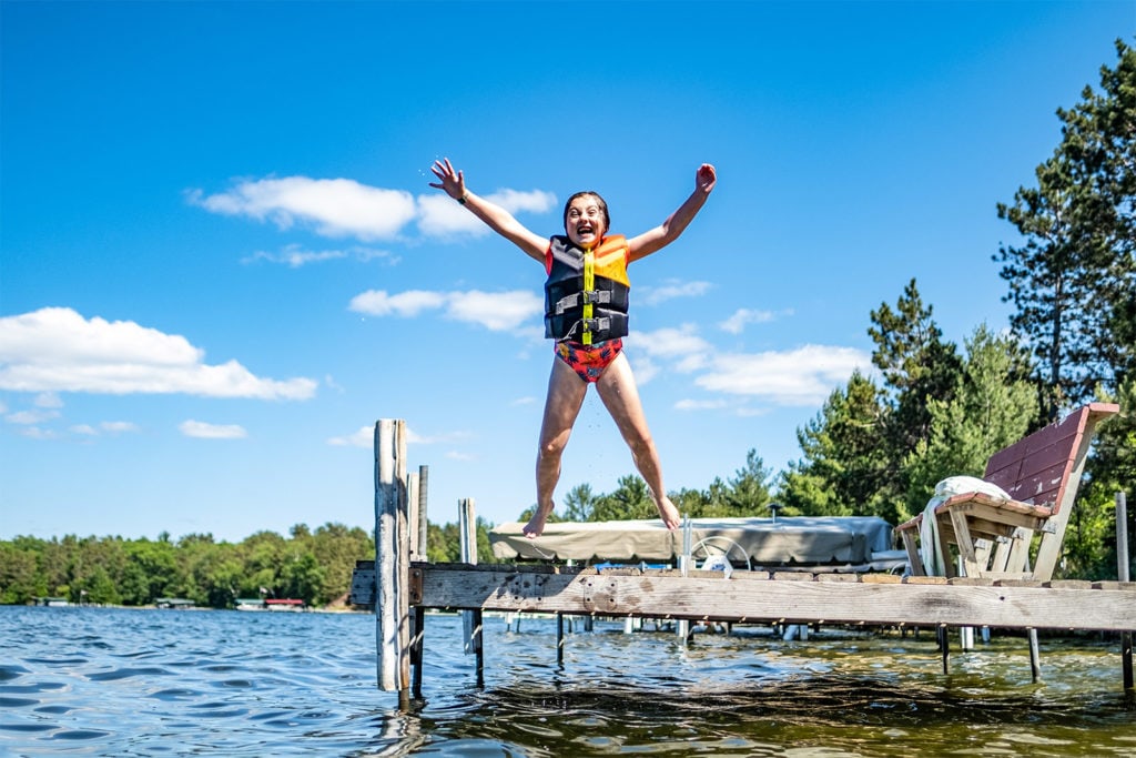 A child jumping off the dock into the water